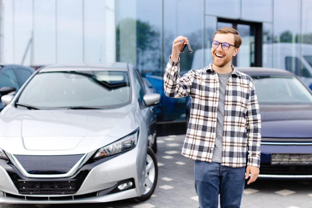 Man holding keys next to car | How to lease a car with bad credit