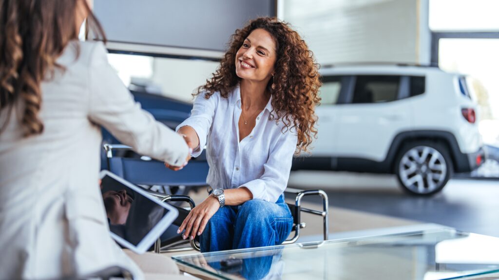 Saleswoman shaking hands | How to lease a car with bad credit