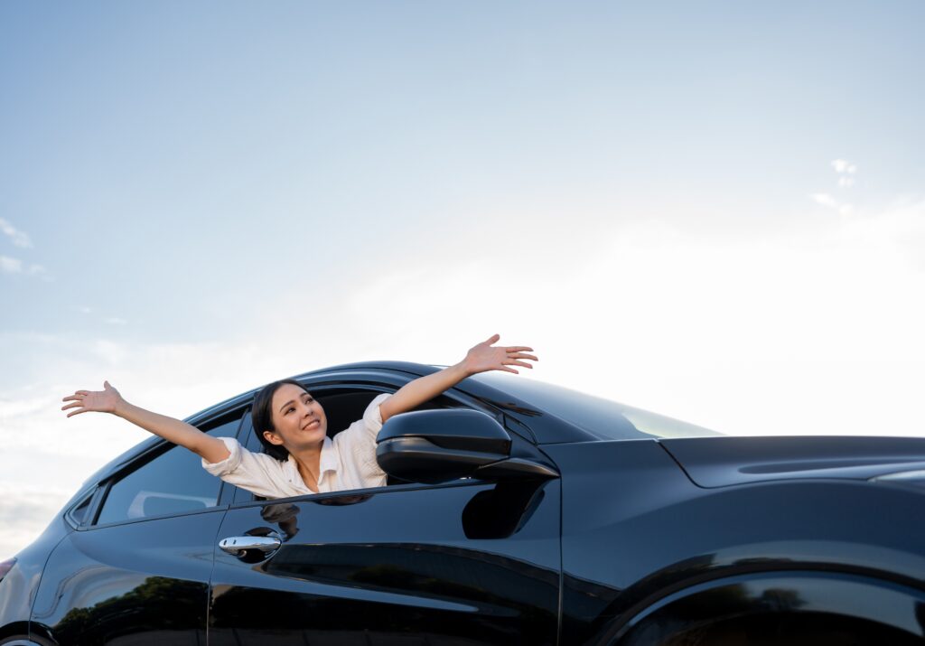 Happy woman in a car | How to get a car loan with bad credit